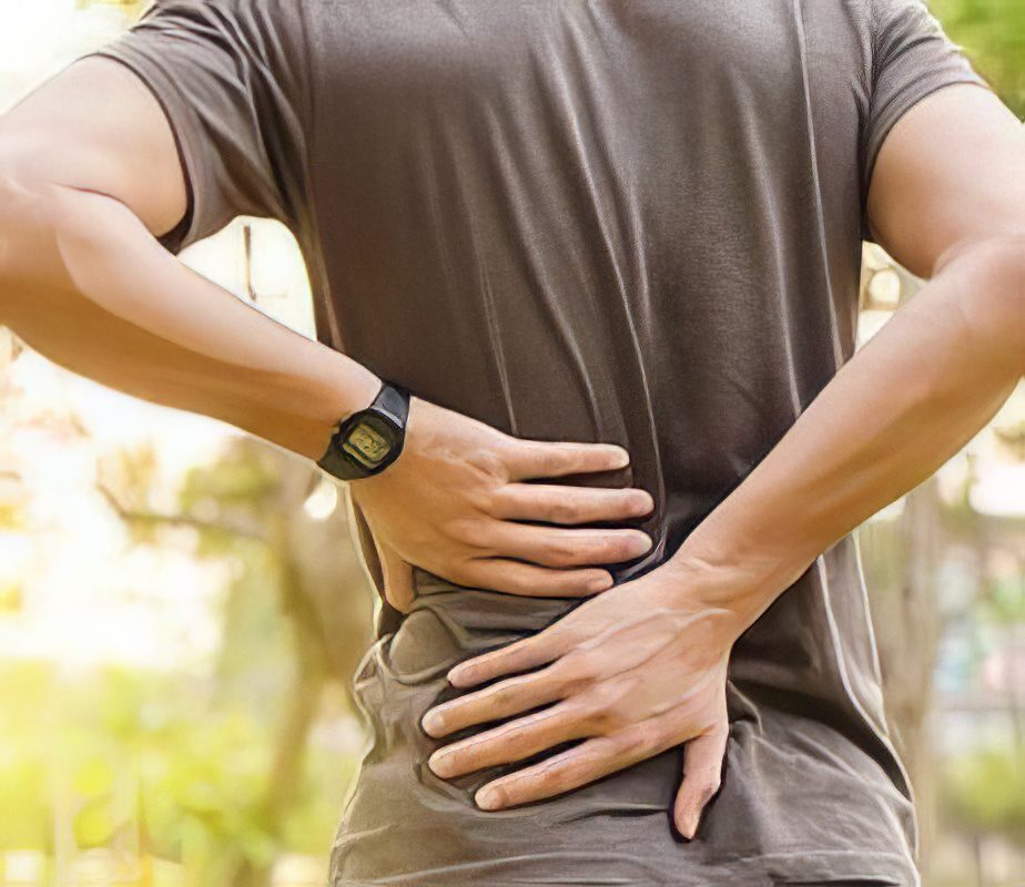 Man holding his lower back before non-surgical back pain treatment